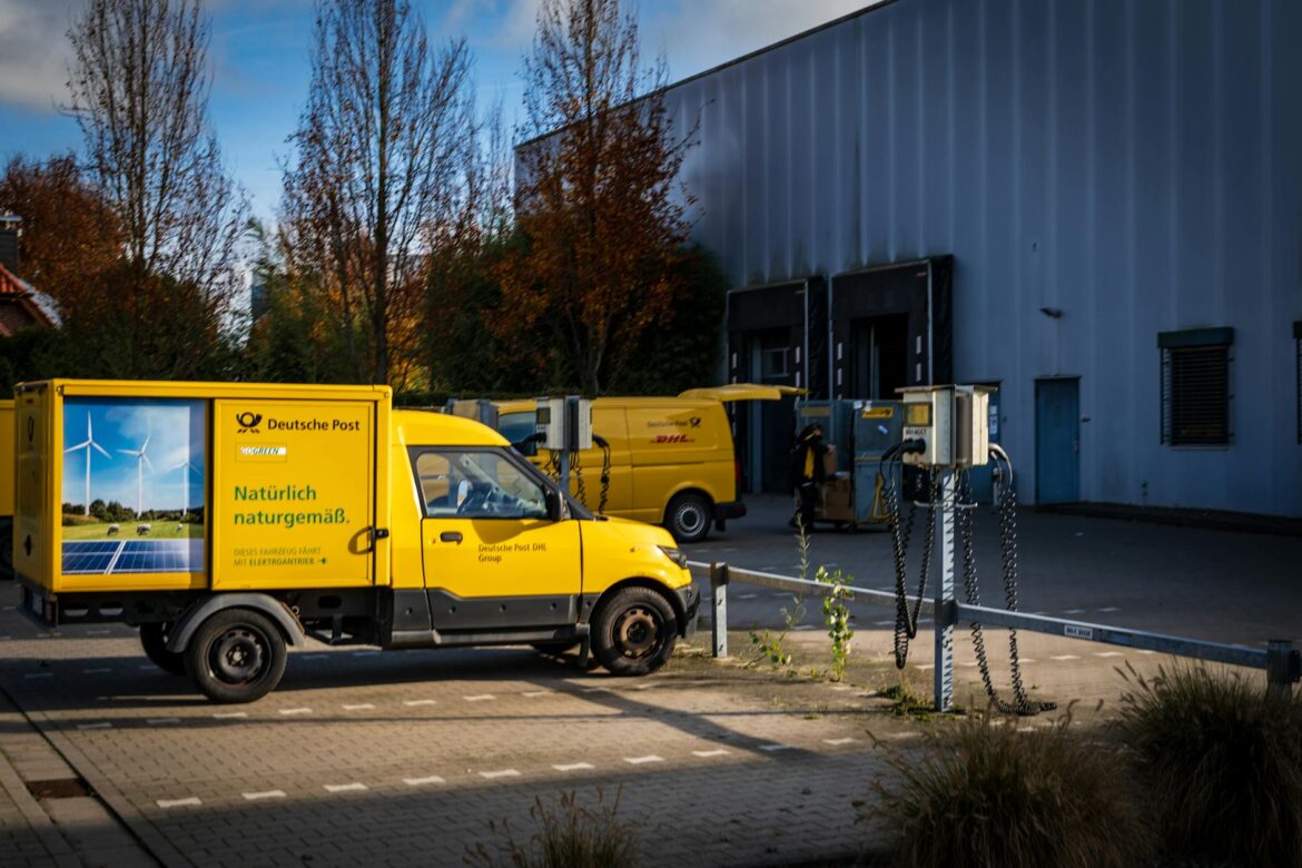 Deutsche Post electric delivery vans parked outdoors emphasizing sustainable logistics.