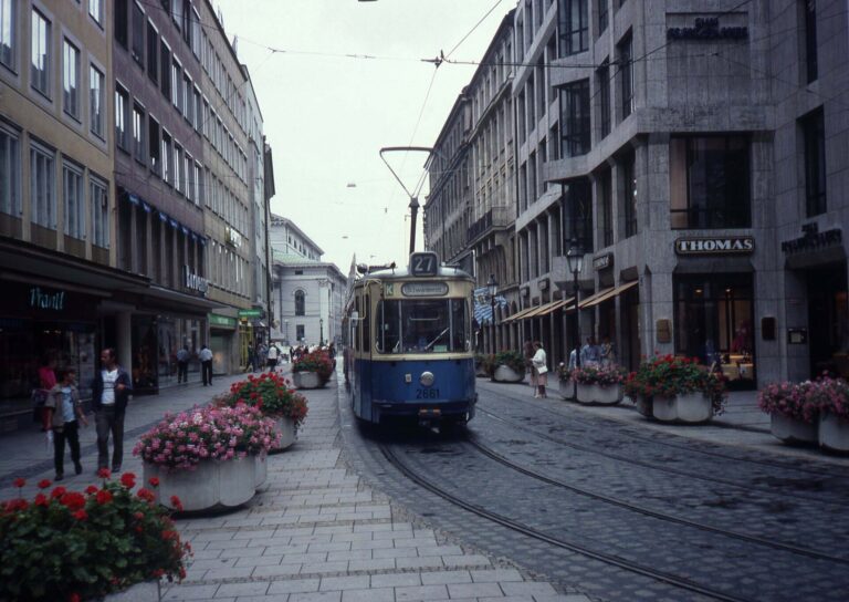 Straße in München mit Straßenbahn Linie 27 und Blumenkübeln