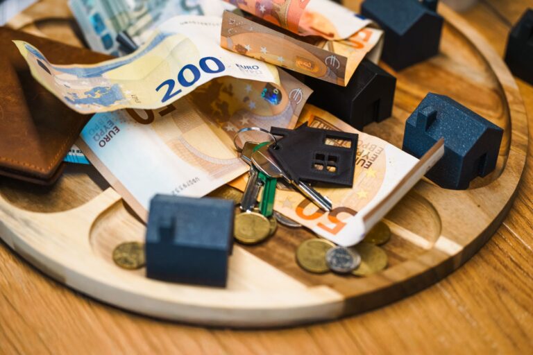 Europäische Familie entspannt am Küchentisch mit Laptop und Geld